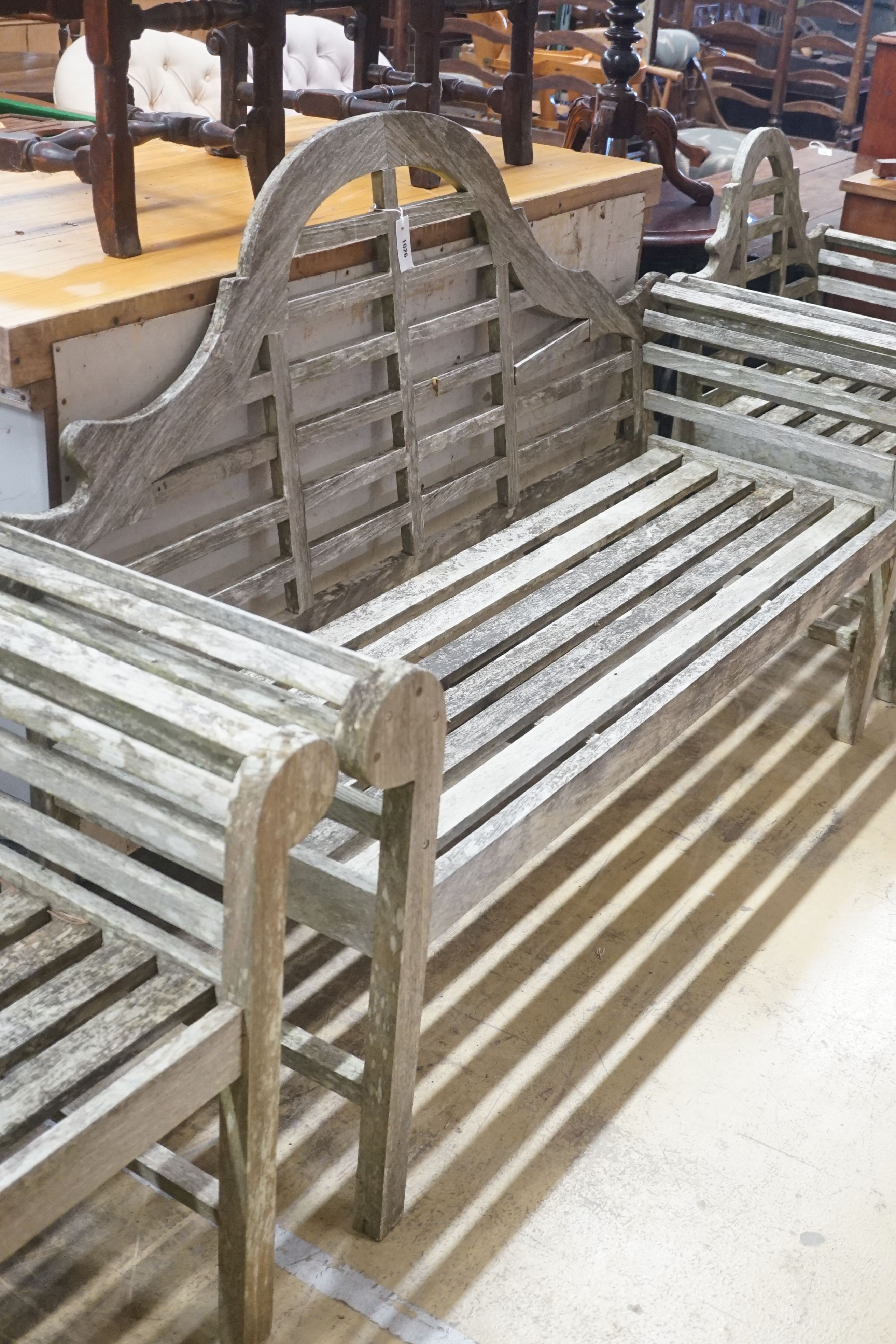 A Lutyens style weathered teak garden bench, width 164cm depth 56cm height 106cm, and two chairs